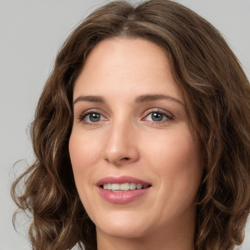 Joyful white young-adult female with long  brown hair and green eyes