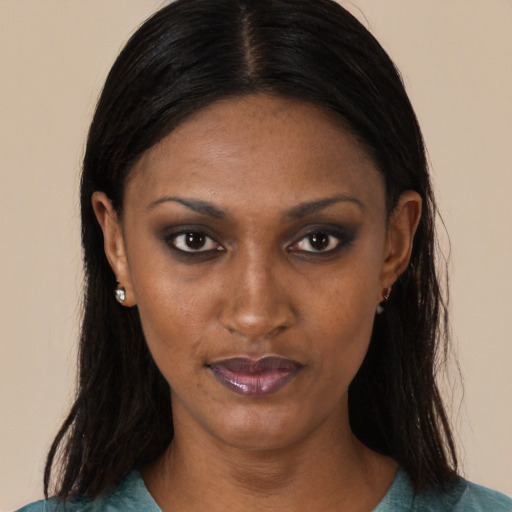 Joyful black adult female with long  brown hair and brown eyes