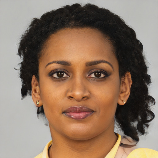 Joyful black young-adult female with long  black hair and brown eyes