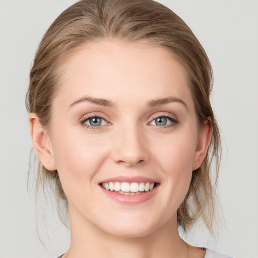 Joyful white young-adult female with medium  brown hair and blue eyes