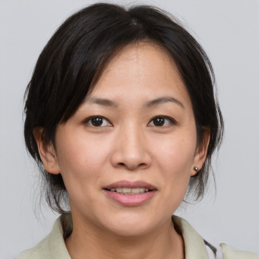 Joyful asian adult female with medium  brown hair and brown eyes
