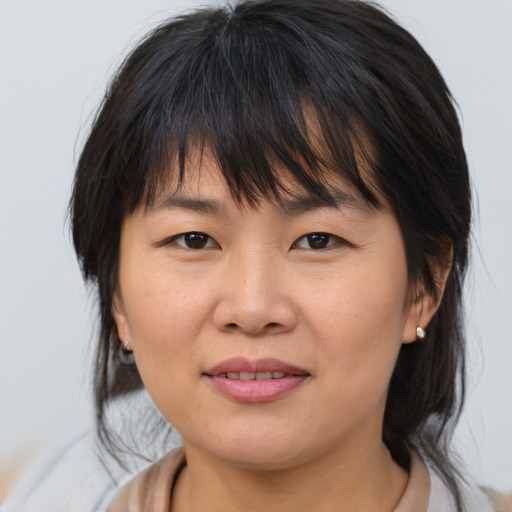 Joyful asian adult female with medium  brown hair and brown eyes