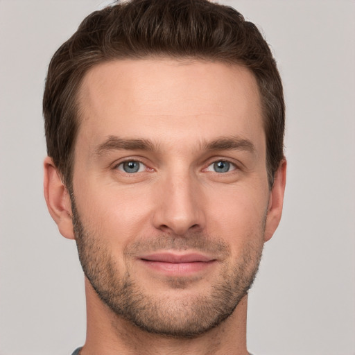 Joyful white young-adult male with short  brown hair and grey eyes