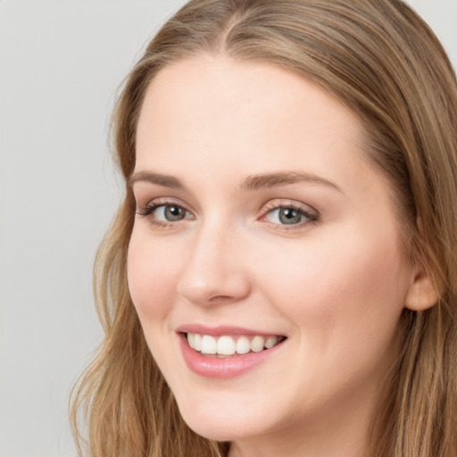 Joyful white young-adult female with long  brown hair and blue eyes