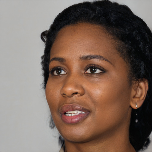 Joyful black young-adult female with medium  black hair and brown eyes