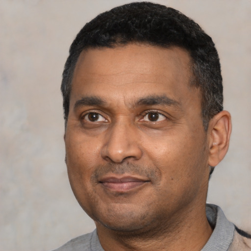 Joyful latino adult male with short  black hair and brown eyes