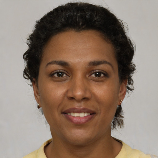 Joyful black young-adult female with short  brown hair and brown eyes