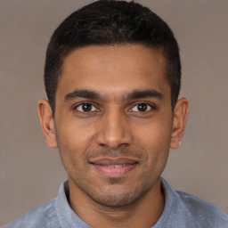 Joyful black young-adult male with short  brown hair and brown eyes