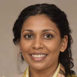 Joyful black adult female with medium  brown hair and brown eyes