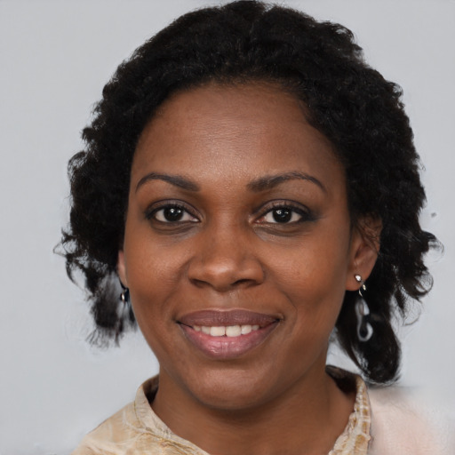 Joyful black adult female with short  brown hair and brown eyes