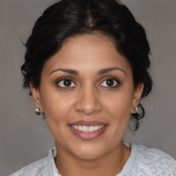 Joyful latino young-adult female with medium  brown hair and brown eyes