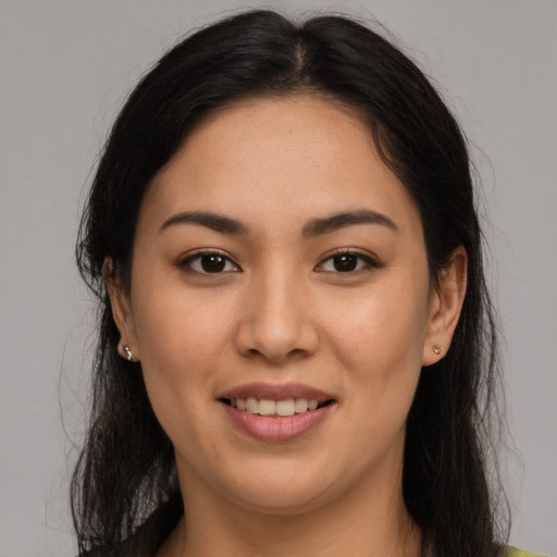 Joyful latino young-adult female with long  brown hair and brown eyes