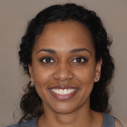 Joyful black young-adult female with medium  black hair and brown eyes