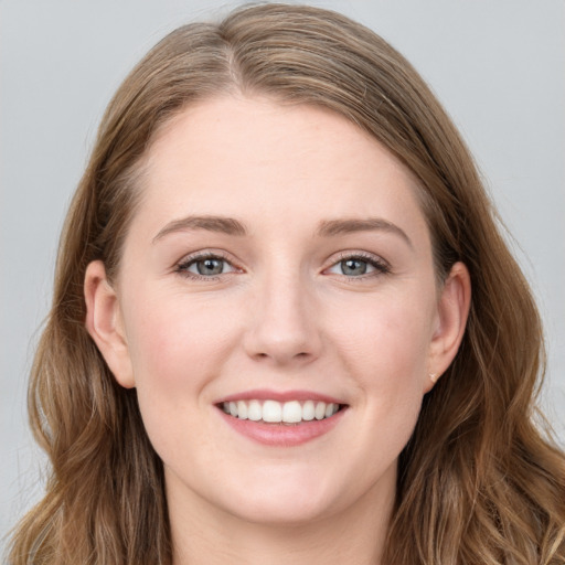 Joyful white young-adult female with long  brown hair and blue eyes