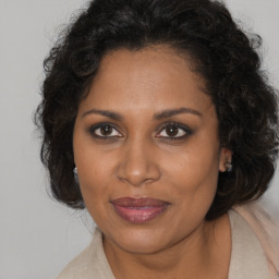 Joyful black adult female with medium  brown hair and brown eyes