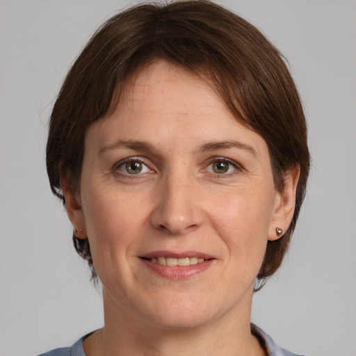 Joyful white adult female with medium  brown hair and grey eyes