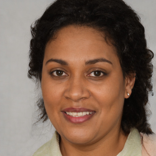Joyful black adult female with medium  brown hair and brown eyes