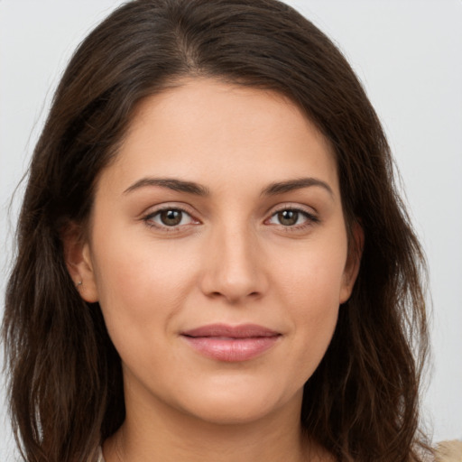 Joyful white young-adult female with long  brown hair and brown eyes