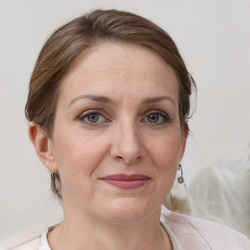 Joyful white adult female with medium  brown hair and grey eyes