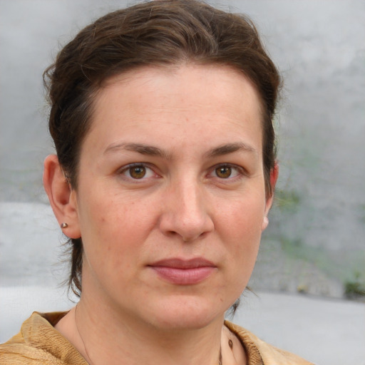 Joyful white adult female with short  brown hair and blue eyes