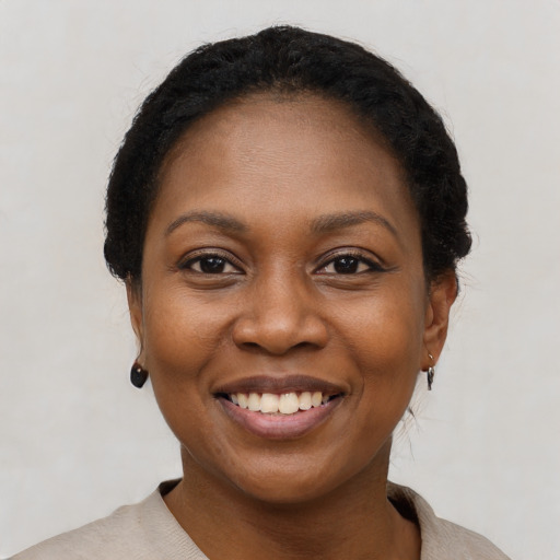 Joyful black young-adult female with short  black hair and brown eyes