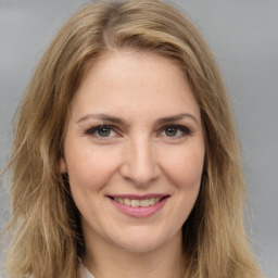 Joyful white young-adult female with long  brown hair and green eyes