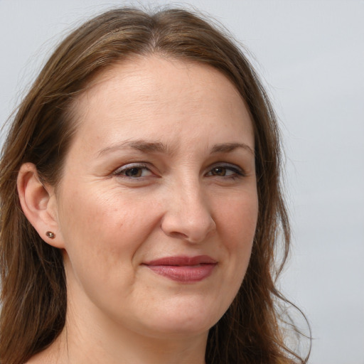 Joyful white adult female with long  brown hair and grey eyes