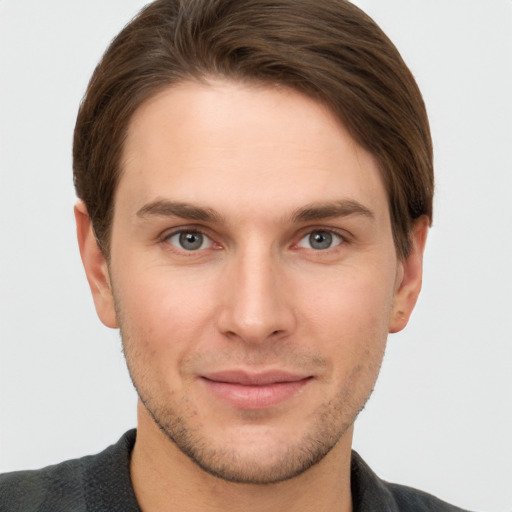 Joyful white young-adult male with short  brown hair and grey eyes