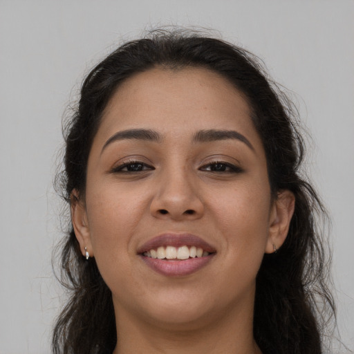 Joyful latino young-adult female with long  brown hair and brown eyes