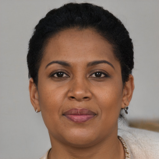Joyful black adult female with short  brown hair and brown eyes