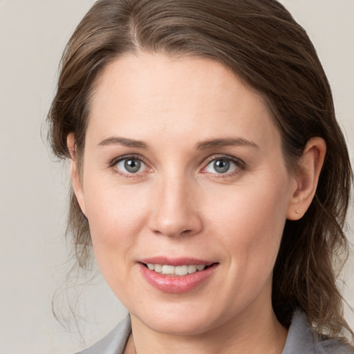 Joyful white young-adult female with medium  brown hair and grey eyes