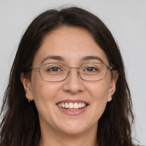 Joyful white adult female with long  brown hair and grey eyes