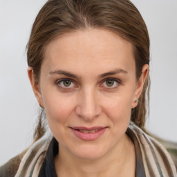 Joyful white young-adult female with medium  brown hair and grey eyes