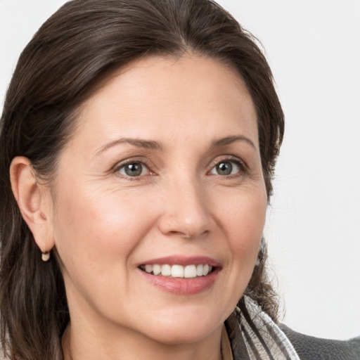 Joyful white adult female with medium  brown hair and grey eyes