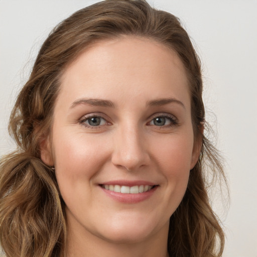 Joyful white young-adult female with long  brown hair and blue eyes