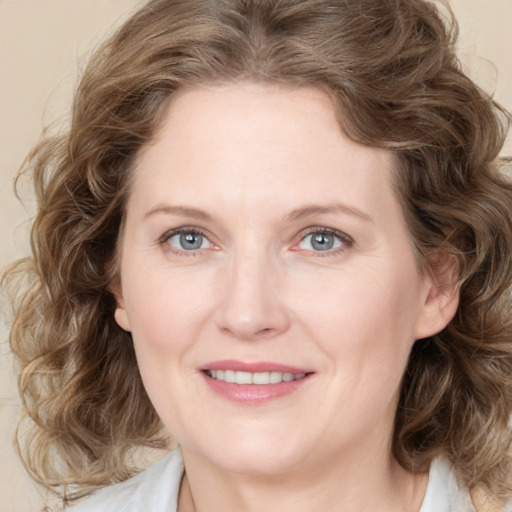 Joyful white young-adult female with medium  brown hair and blue eyes