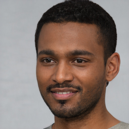 Joyful black young-adult male with short  black hair and brown eyes