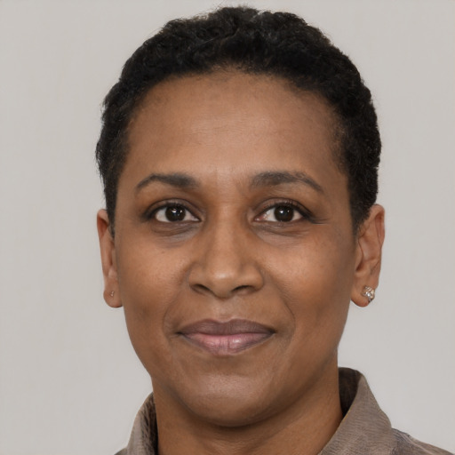 Joyful black adult female with short  black hair and brown eyes