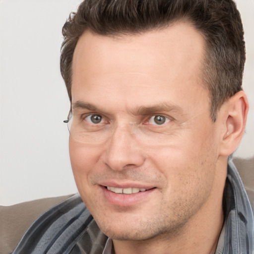 Joyful white adult male with short  brown hair and brown eyes