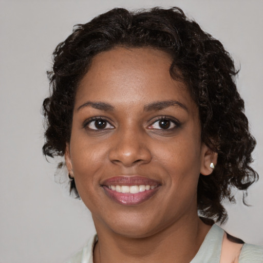 Joyful black young-adult female with medium  brown hair and brown eyes