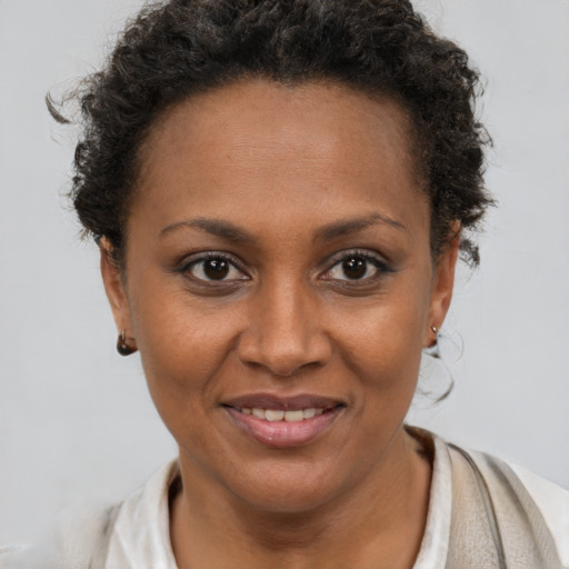 Joyful black young-adult female with short  brown hair and brown eyes