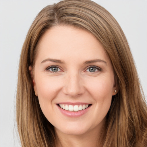 Joyful white young-adult female with long  brown hair and brown eyes