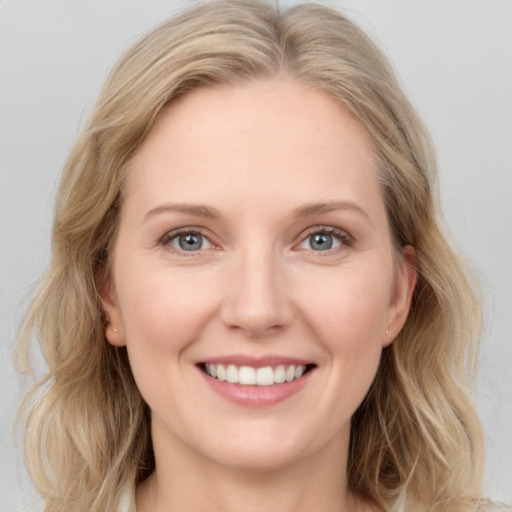 Joyful white young-adult female with medium  brown hair and blue eyes