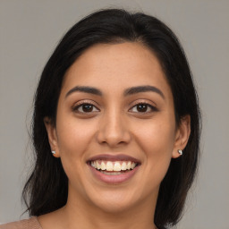 Joyful latino young-adult female with medium  brown hair and brown eyes