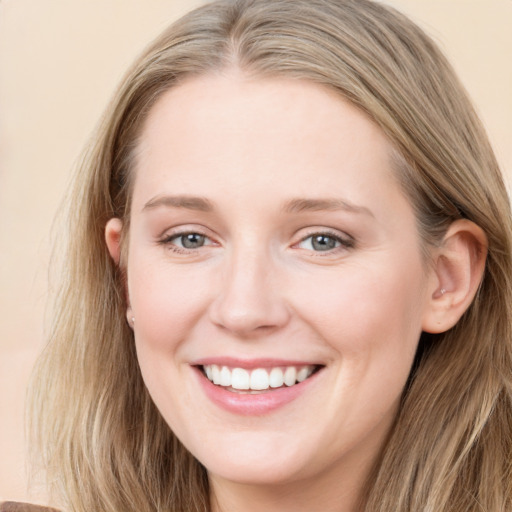 Joyful white young-adult female with long  brown hair and blue eyes