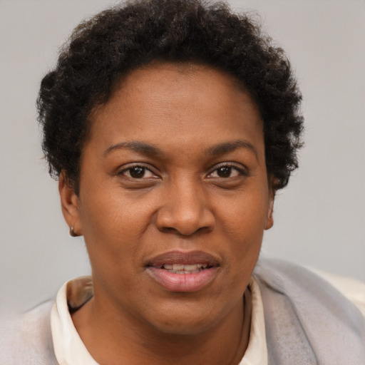 Joyful black young-adult female with short  brown hair and brown eyes