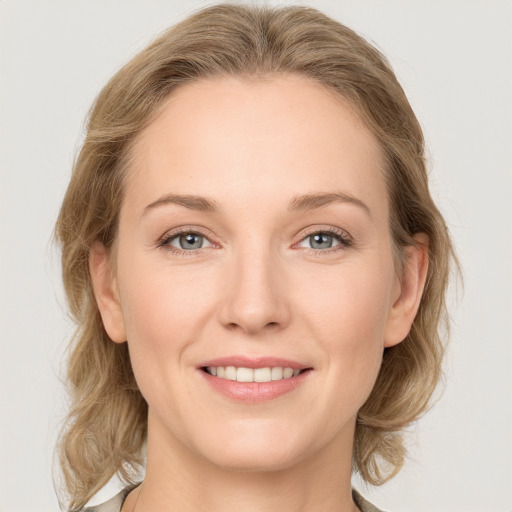 Joyful white young-adult female with medium  brown hair and blue eyes