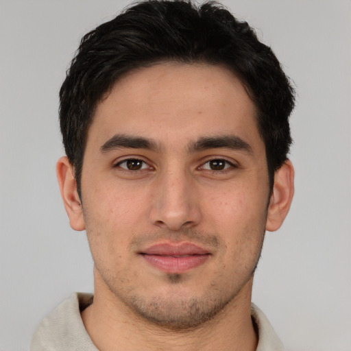 Joyful latino young-adult male with short  brown hair and brown eyes