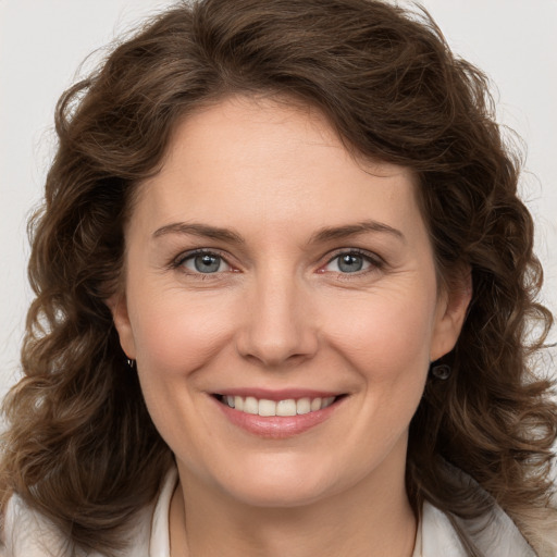 Joyful white young-adult female with medium  brown hair and green eyes