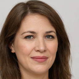 Joyful white adult female with long  brown hair and brown eyes